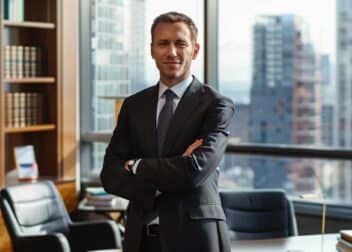 a professional car accident injury lawyer stands confidently in a modern office adorned with legal books and a cityscape view, exuding expertise and assurance as they prepare to assist clients navigating their difficult circumstances.