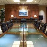 a sleek, modern law office in houston, featuring a conference room with a large glass table, filled with legal documents and accident case files, illuminated by warm, professional lighting, conveying a sense of expertise and trust in legal aid resources.